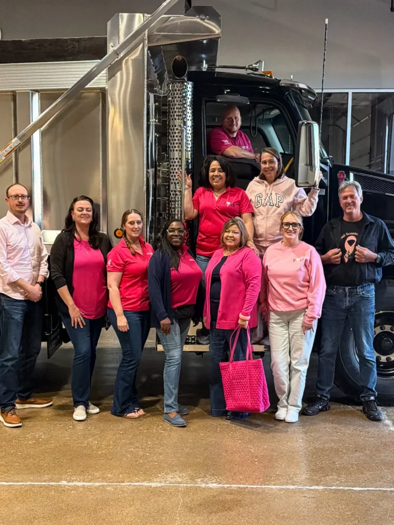 Palmer employees at Kenworth of Indianapolis East wearing pink standing in front of a Kenworth T880